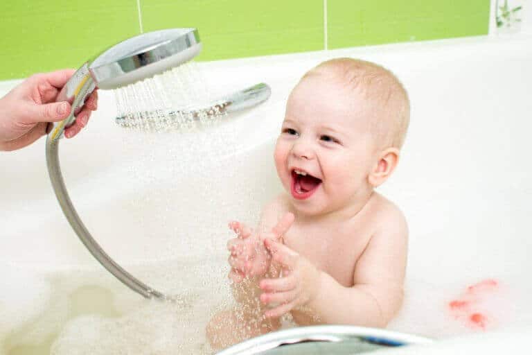 Healthy, smiling baby enjoying bath on a water softener system
